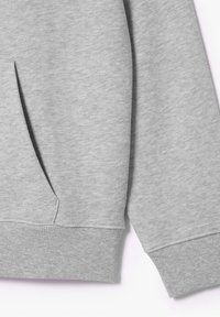 Jasnoszara bluza z prążkowanym dołem i mankietami, miękką teksturą oraz kieszenią kangurką z przodu dla funkcjonalności.