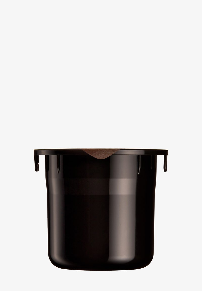 Pequeña cápsula de café negra con una tapa plana marrón, diseñada para máquinas de café de un solo uso, centrada sobre un fondo blanco.