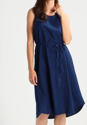 Robe bleu marine sans manches avec un corsage ajusté et un ourlet asymétrique évasé. Dotée d'une ceinture à nouer à la taille et d'un tissu texturé.