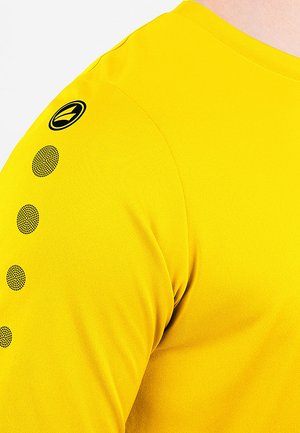 Bright yellow short-sleeve shirt with textured black graphic and logo on the shoulder. Smooth fabric with a fitted shape.