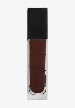 Bouteille rectangulaire en verre transparent avec un liquide brun foncé et un bouchon rectangulaire noir, comportant un design géométrique noir minimaliste à l'avant.