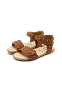 Sandalias marrones con parte superior estampada que presenta formas geométricas en azul y marrón claro. Cintas ajustables, suela plana y plantilla acolchada.