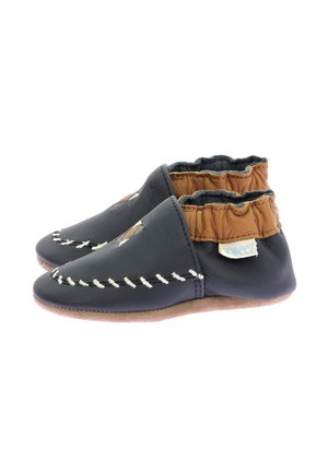 Chaussures en cuir pour bébé avec une surface bleu marine, un bracelet élastique couleur beige et des coutures blanches. Semelle souple pour flexibilité et confort.