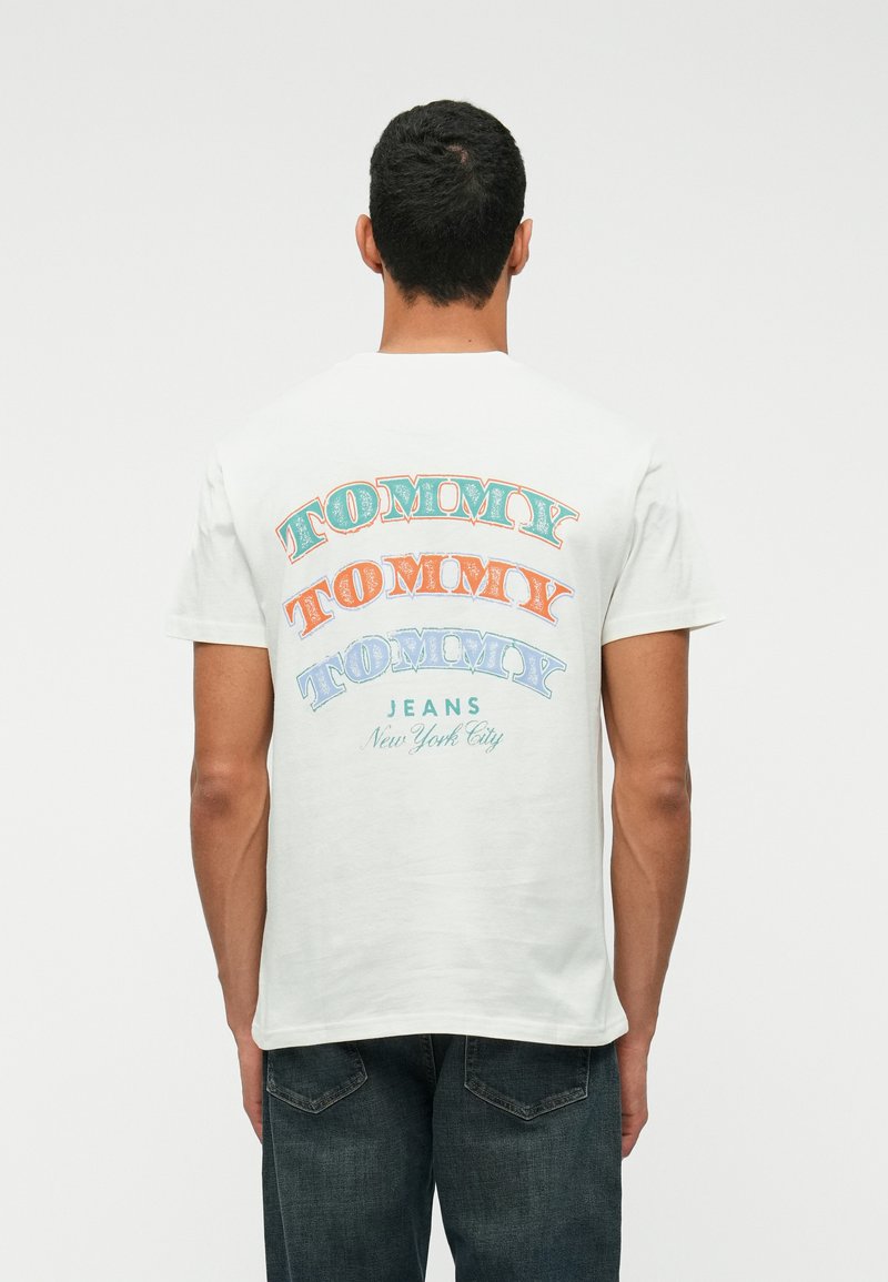 Tricou alb din bumbac, cu text îndrăzneț și multicolor "TOMMY" în diferite stiluri pe spate, iar dedesubt "JEANS New York City".