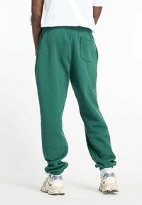 New Balance SPORT ESSENTIALS JOGGER - Pantalones deportivos - green