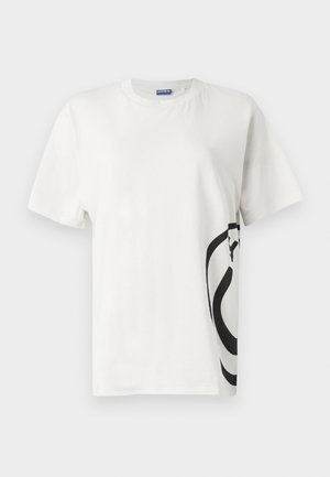 Bílá bavlněná tričko s velkým černým abstraktním grafickým vzorem na levé straně, krátké rukávy a kulatým výstřihem.