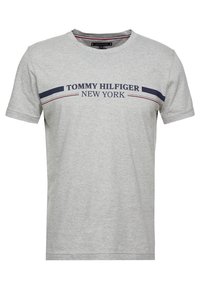 Grau Baumwoll-T-Shirt mit dunkelblauen und roten Streifen, auf dem "TOMMY HILFIGER NEW YORK" in der Brustmitte aufgedruckt ist. Mit Rundhalsausschnitt und kurzen Ärmeln.