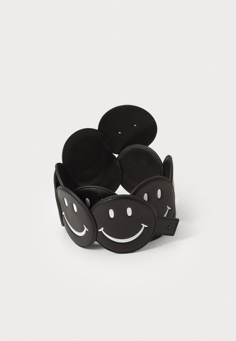 Cintura in pelle nera con pannelli circolari che presentano design di faccine sorridenti bianche. Texture liscia, cintura regolabile e stile minimalista.