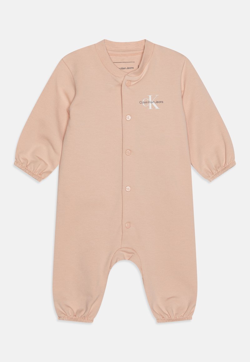 Απαλή ροζ φόρμα μωρού φτιαγμένη από μαλακό βαμβάκι. Διαθέτει μακριά μανίκια, κλείσιμο με κουμπιά, gathered cuffs και ένα μικρό λογότυπο στο στήθος.