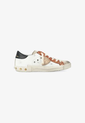 Sneaker bianca con linguetta nera, striscia di glitter rame, lacci beige e segni di usura sporca sulla suola e sulle punte.