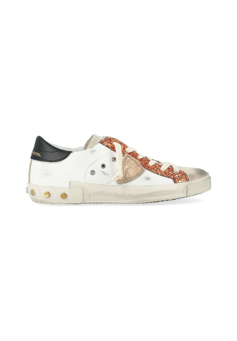 Sneaker bianca con linguetta nera, striscia di glitter rame, lacci beige e segni di usura sporca sulla suola e sulle punte.