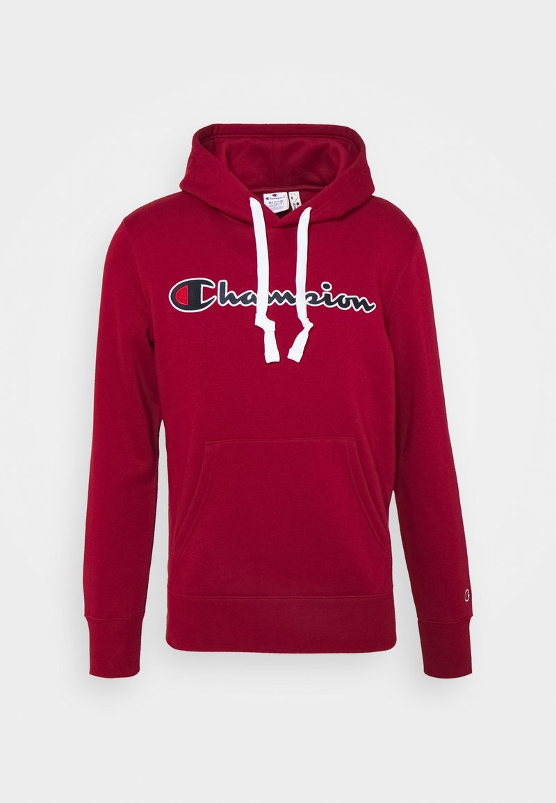 Sudadera con capucha roja de forro polar con un bolsillo frontal. Presenta cordones blancos y el logo de "Champion" en blanco y negro en el pecho.