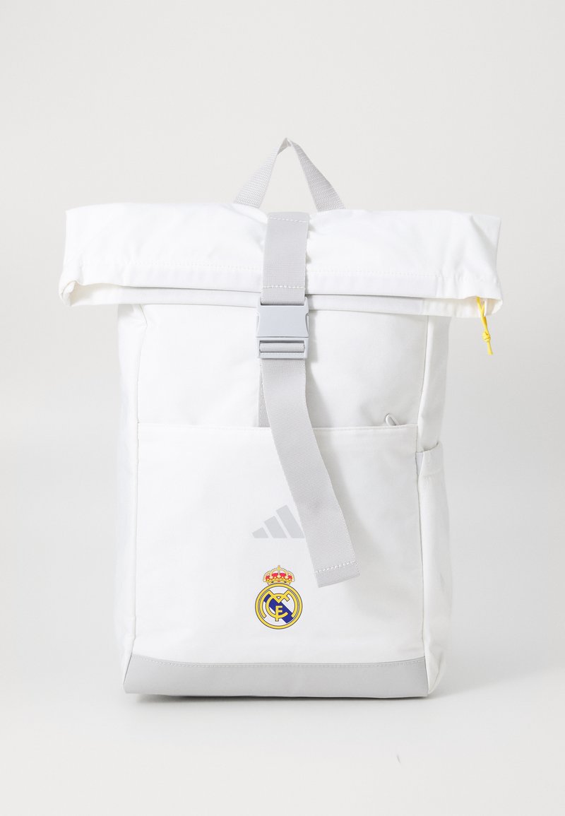 White roll-top backpack with gray accents, featuring a silver buckle and front pocket. Displays Real Madrid logo and Adidas branding.