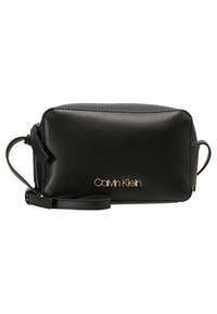 Černá kožená taška se zlatým logem. Obdélníkový tvar, texturovaný povrch a nastavitelný popruh. Kompaktní design s minimem hardwarových detailů.