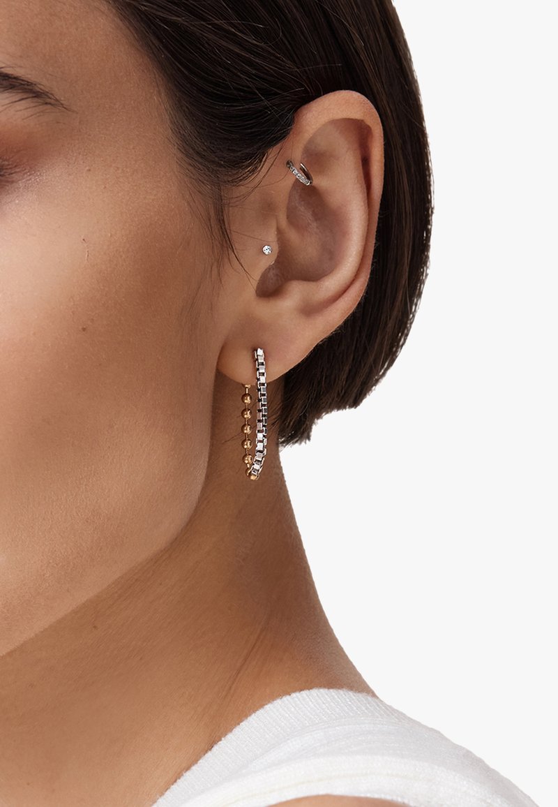 Gli orecchini a cerchio in oro e argento presentano perline rotonde alternate e un design a barra elegante, evidenziando diverse trame e finiture.