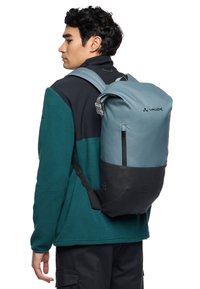 Zaino con design bicolore: parte superiore blu chiaro, parte inferiore nera. Realizzato in tessuto resistente con una forma elegante. Dispone di spallacci regolabili e tasca frontale.