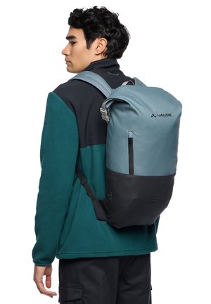 Sac à dos au design bicolore : partie supérieure bleu clair, partie inférieure noire. Fabriqué en tissu durable avec une forme épurée. Dispose de bretelles ajustables et d'une poche avant.