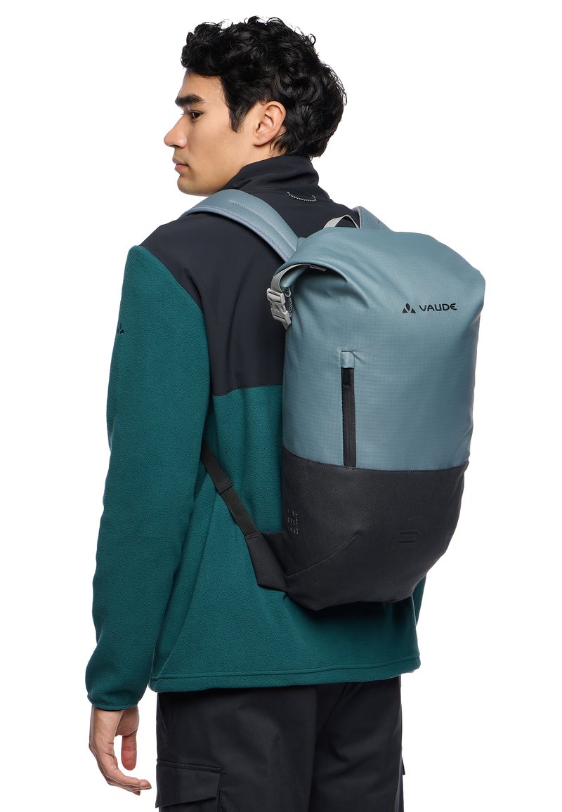 Zaino con design bicolore: parte superiore blu chiaro, parte inferiore nera. Realizzato in tessuto resistente con una forma elegante. Dispone di spallacci regolabili e tasca frontale.