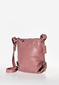 Borsa a tracolla in pelle di un rosa tenue. Presenta una chiusura con zip, una tracolla regolabile e dettagli decorativi in metallo sui lati. Texture liscia.