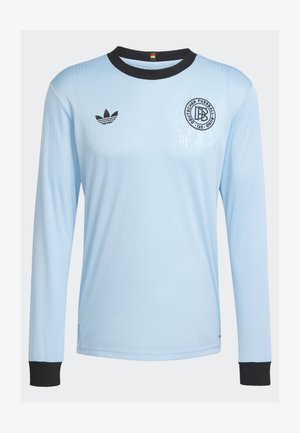 Lyseblå langærmet trøje med ribbet tekstur, sort krave og manchetter. Har et Adidas-logo og et rundt emblem på brystet.