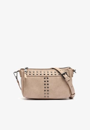 Béžová kožená crossbody taška s kovovými nýty podél horní a přední části. Má zipové zapínání a nastavitelny popruh. Hladký povrch.