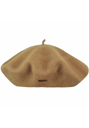Beret z wełny koloru wielbłądziego z małym szczytem u góry oraz czarną etykietą marki Kangol z przodu.