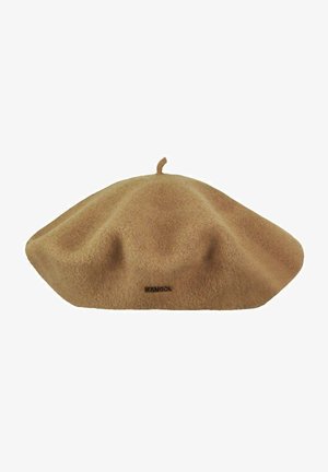 Béret en laine couleur chameau avec une petite tige sur le dessus et une étiquette de marque Kangol noire à l'avant.