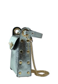 Metalen zilveren handtas met een gestructureerd ontwerp, voorzien van gouden beslag, decoratieve studs en een kettingriem. Inclusief een voorflap sluiting.