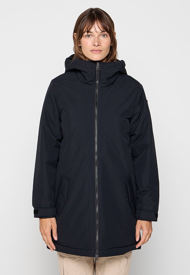 Parka bleu marine foncé avec capuche, fermeture éclair devant et poches latérales. Présente une coupe légèrement surdimensionnée et un tissu lisse, résistant à l'eau.