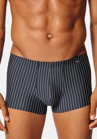 Mörkblå boxerkalsonger med vita vertikala ränder, tillverkade av ett slätt material. Har en åtsittande passform och en medellång design.