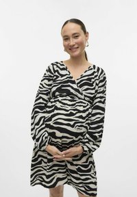 Robe de maternité à motif zèbre en noir et blanc, avec un design croisé, des manches longues et une taille élastiquée pour plus de confort.