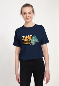 Námořnické modré tričko s kresleným stegosaurusem a žlutým textem "ČASOVÝ CESTOVATEL Z JINÉHO SVĚTA JURASSIC PORTAL."