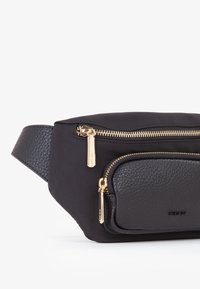Marsupio in nylon nero con tasca frontale in pelle. Presenta cerniere dorate, una finitura testurizzata e una tracolla regolabile.
