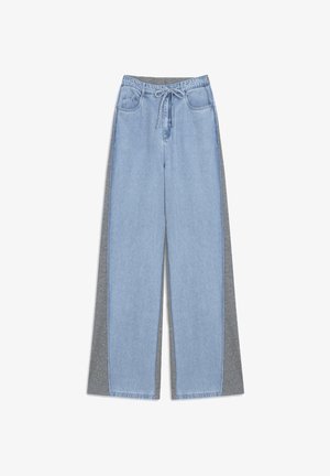 Jeans ampi azzurri con pannelli laterali grigi, dotati di vita con cordino e due tasche frontali. Il denim ha una consistenza liscia.