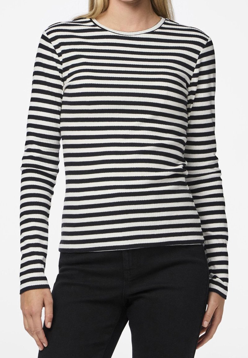 Långärmad ribbad topp med svart och vit horisontell randning, rund halsringning och figurnära silhuett.
