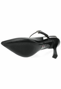 Scarpa nera con tacco alto, punta appuntita, finitura lucida, cinturino sottile alla caviglia e suola in gomma testurizzata per miglior grip.