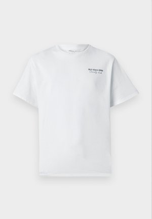 Camiseta de algodón blanca con mangas cortas, cuello redondo, que presenta un pequeño logotipo de texto en negro "J&J desde 1990 Society Club" en el pecho.