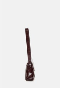 Borsa a mano in pelle marrone con forma rettangolare, base piatta, manico lungo e hardware minimale. Superficie texturizzata con una finitura liscia.