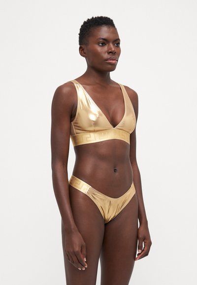 Bikini métallisé doré avec un décolleté plongeant et une large bande, présentant un design texturé et un motif géométrique sur la ceinture.