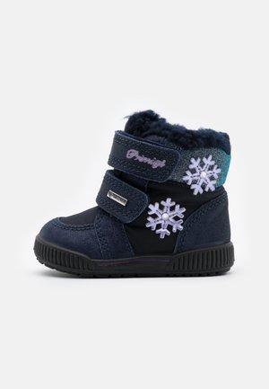 Botte d'hiver bleu marine avec deux sangles Velcro, doublure en fausse fourrure et accents de flocon de neige brodés en violet avec des détails en gemmes. Semelle en caoutchouc.