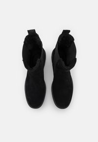Czarne botki sięgające do kostki, z zamszowym wykończeniem, miękkim, teksturowanym wnętrzem i solidnymi podeszwami. Posiadają pętle z tyłu ułatwiające zakładanie.