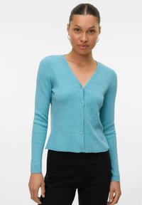 Cardigan côtelé bleu clair avec un col en V et des manches longues, doté de boutons argentés sur le devant et d'un ourlet légèrement court.