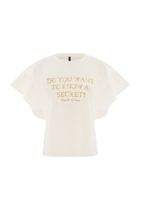T-shirt blanc à manches courtes avec de larges manches et un texte doré qui dit "VEUX-TU CONNAÎTRE UN SECRET ? Manila Grace."