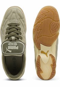 Baskets de sport en daim vert avec un design cousu, semelle en caoutchouc et languette rembourrée arborant un logo "PUMA KING" en blanc.