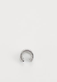 Silberring mit einem strukturierten, offenen Design, das gerippte Kanten und eine polierte Oberfläche aufweist, die seine kreisförmige Form und die geschichteten Elemente hervorhebt.