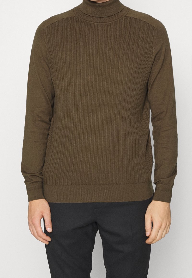 Brauner gerippter Rollkragenpullover mit langen Ärmeln, der ein strukturiertes Strickmuster und eine taillierte Passform aufweist.