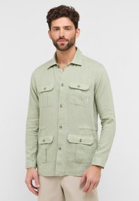 Lichtgroen, langemouw shirt van linnen met een button-down kraag, twee borstzakken en een ontspannen pasvorm. Heeft knoopaccenten.