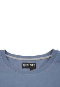 Sininen puuvillapaita, jossa on pyöreä kaula-aukko, harmaa kaula-aukko ja musta etiketti, jossa lukee "HONESTY RULES". Silkkinen rakenne.
