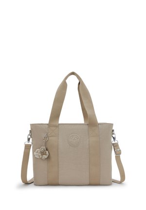 Borsa a mano beige con manici larghi in tessuto, tracolla removibile, toppa rotonda con logo e portachiavi con scimmietta in peluche attaccato.