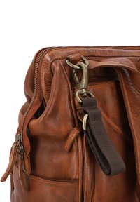 Bolso de cuero marrón con costuras visibles, cierre con cremallera y un gancho de metal. Cuenta con una correa de tela y varios bolsillos para almacenamiento.